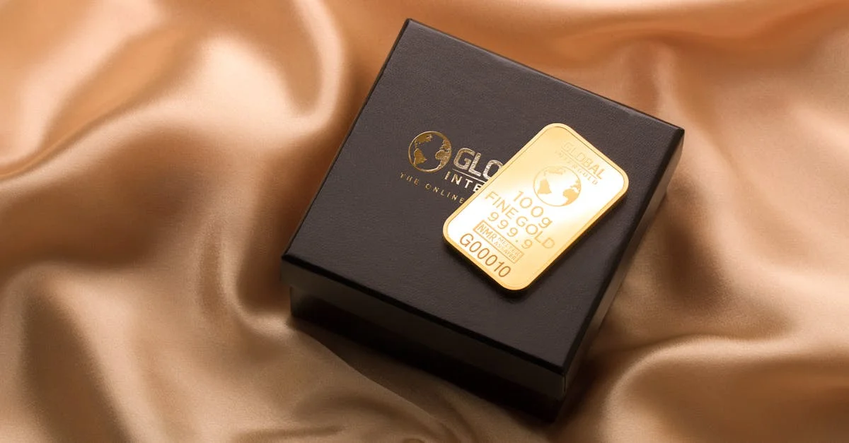 A pristine gold bar resting on a luxurious black box atop a smooth silk fabric.