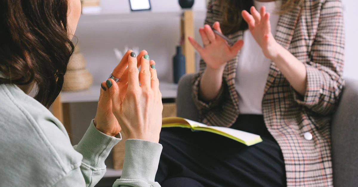 Two women engaged in a therapy session, communication and support in an office setting.